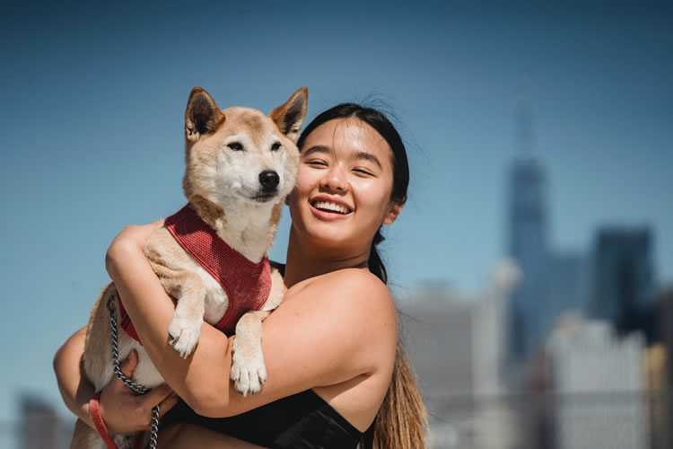 Happy woman holding dog. Photo by Sam Lion from Pexels.