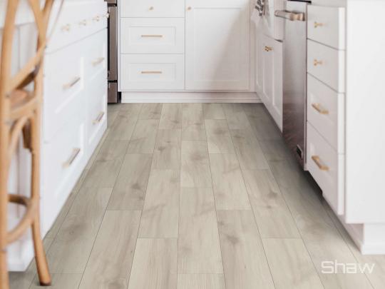 Room scene with Intrigue laminate flooring by Shaw, in Delicate Maple